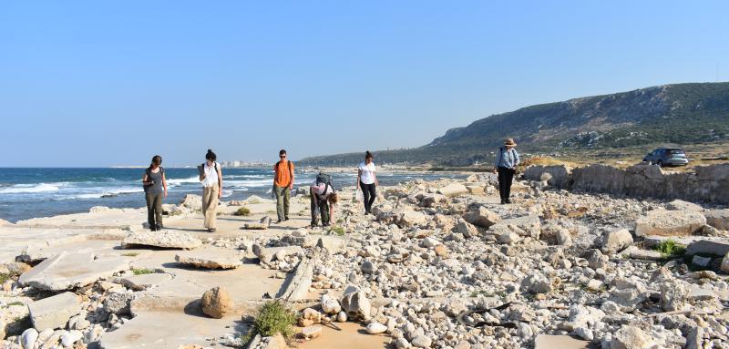 Archaeology students walking along coastline